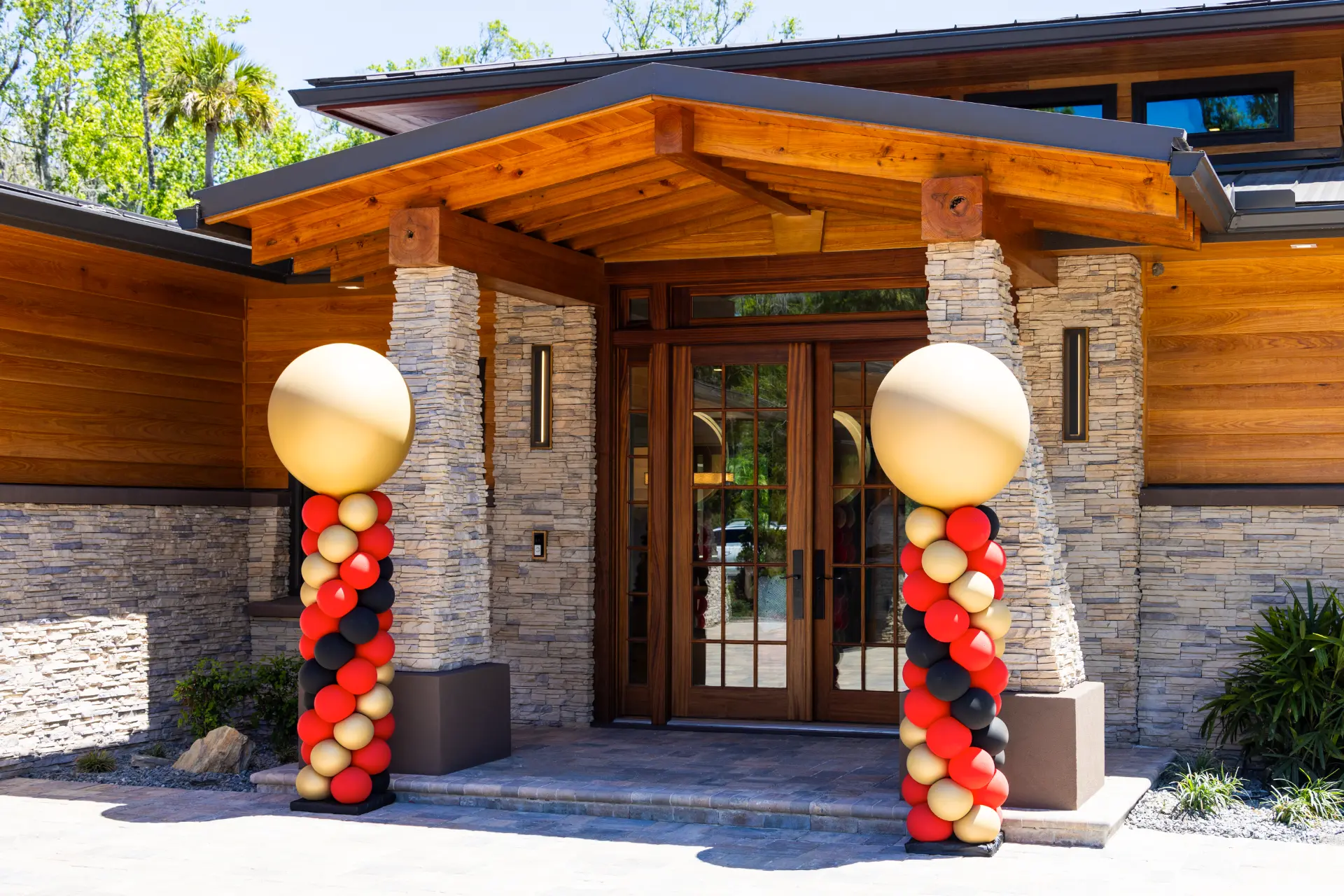 main entrance of Japandi house with balloon pillars set before stone columns