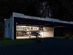 hangar home with garage bay door open at night and plane partly out of garage area.