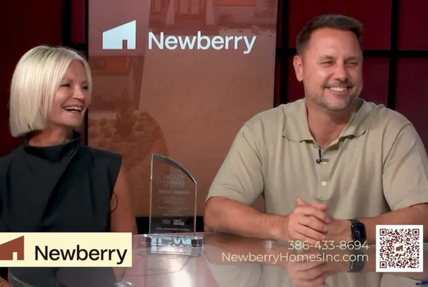Chad Newberry and Lisa Foor of Newberry Homes smiling beside their Parade of Homes Merit Award during a You Have Real Estate TV interview