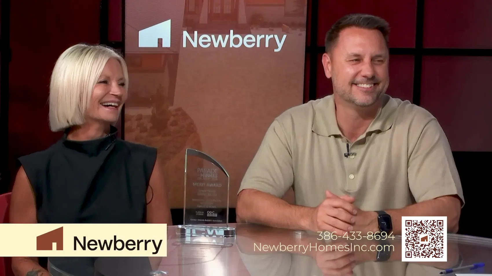 Chad Newberry and Lisa Foor of Newberry Homes smiling beside their Parade of Homes Merit Award during a You Have Real Estate TV interview