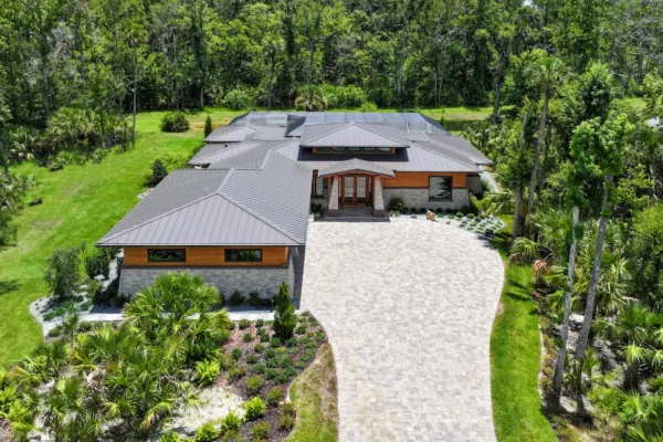 view of japandi home with curved driveway and natural landscaping