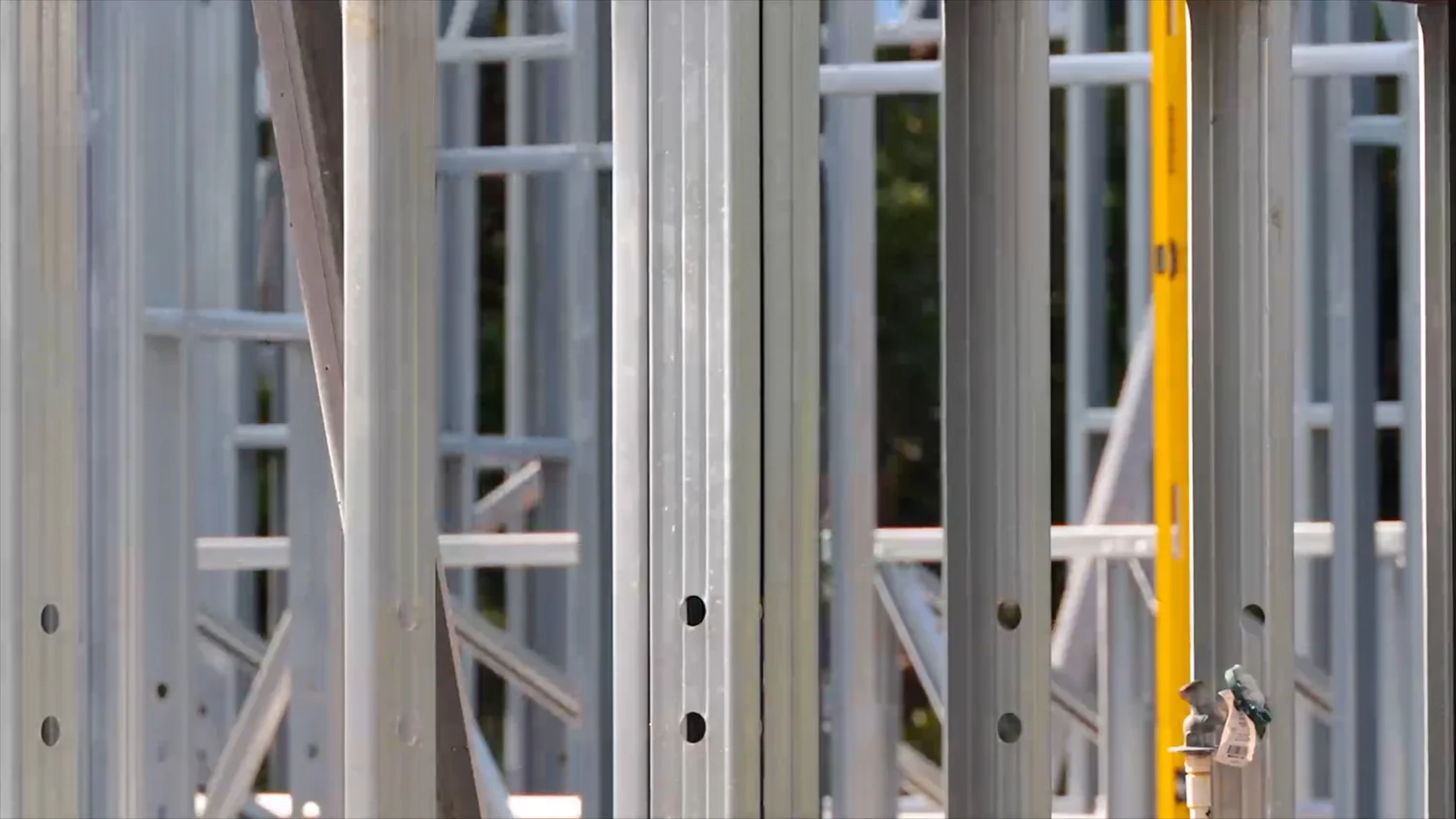 Close-up detail of light gauge galvanized steel framing studs and tracks assembled on a residential construction site