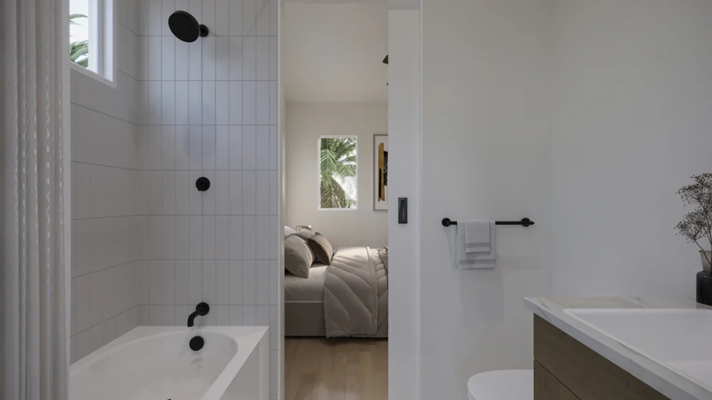Miranda model guest bathroom with a tiled tub-shower, black fixtures, and a view into the bedroom at Six in the City, College Park Orlando