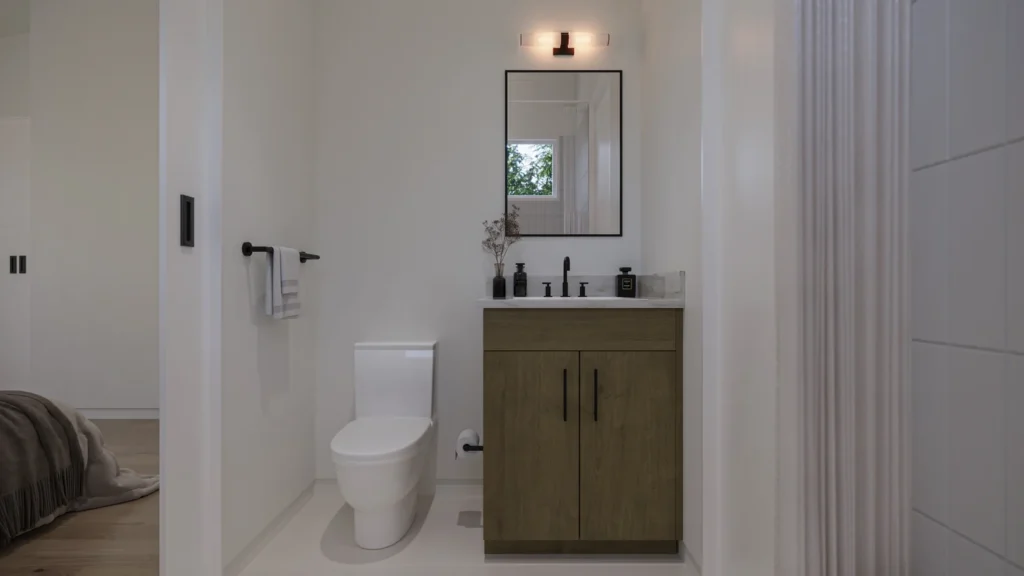 Miranda model guest bathroom with a wood vanity, marble counter, and black fixtures at Six in the City, College Park, Orlando