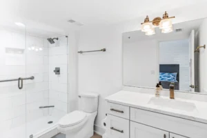After bathroom remodel featuring white quartz vanity, modern lighting, and clean contemporary design by Newberry Homes in New Smyrna Beach, Florida