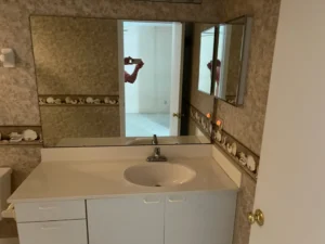 Before bathroom remodel showing dated vanity, sea shells wall tile, and original fixtures prior to renovation by Newberry Homes in Central Florida