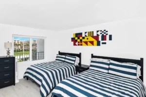 After bedroom remodel featuring modern guest bedroom design with clean lines and updated furnishings by Newberry Homes in New Smyrna Beach just south of Daytona Beach Florida.