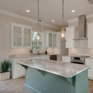Custom kitchen with marble island, white cabinetry, glass-front uppers, stainless steel appliances, and coastal finishes in Ponce Inlet Florida by Newberry Homes