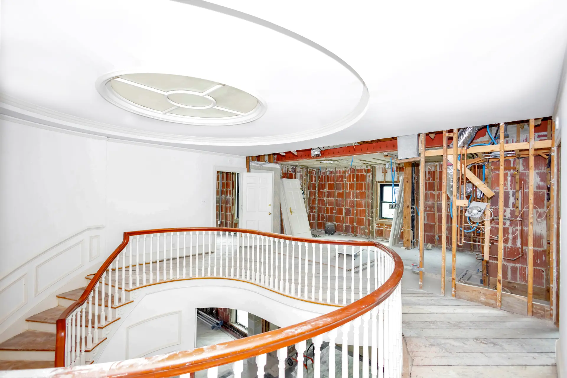 Coastal whole home remodeling project by Newberry Homes in Daytona Beach Florida. Interior top of staircase, demolition of walls in process and revealing brick and framing.