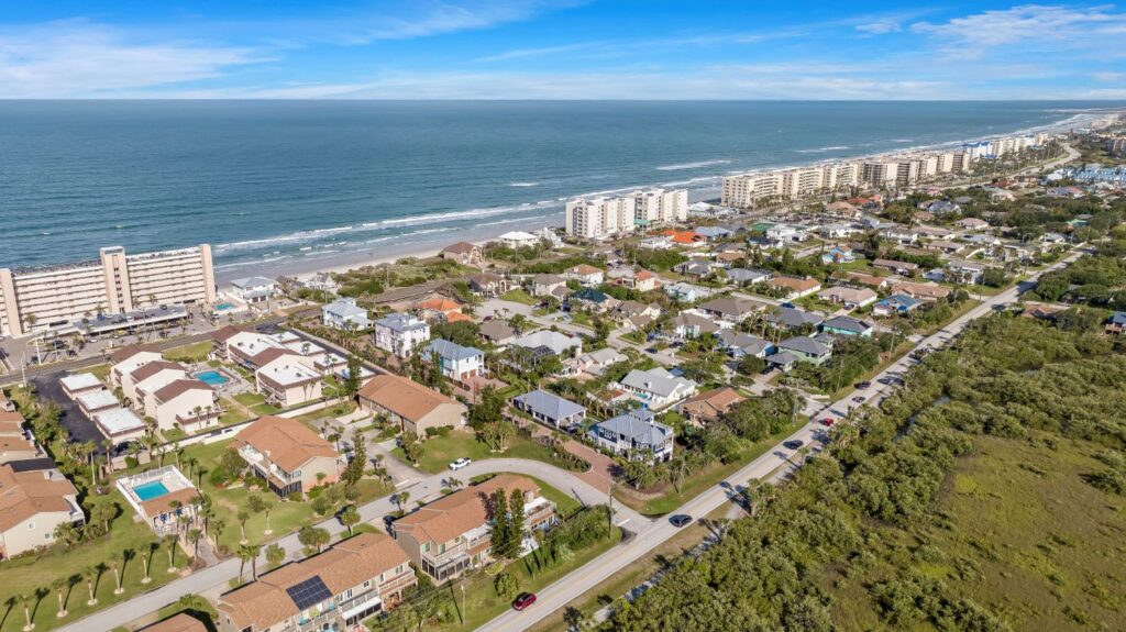Aerial view of the Ponce Inlet Key neighborhood and Atlantic Ocean coastline near The Mallory custom home by Newberry Homes, Volusia County, FL