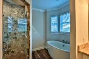 Primary bathroom in The Mallory custom home by Newberry Homes with a freestanding soaking tub, tiled walk-in shower, and bay window, Volusia County, FL